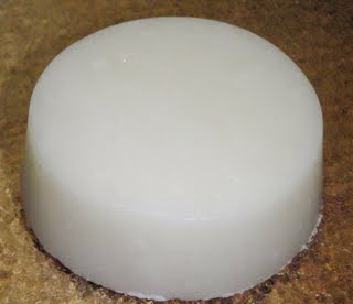 Round white sugar scrub bar on brown background