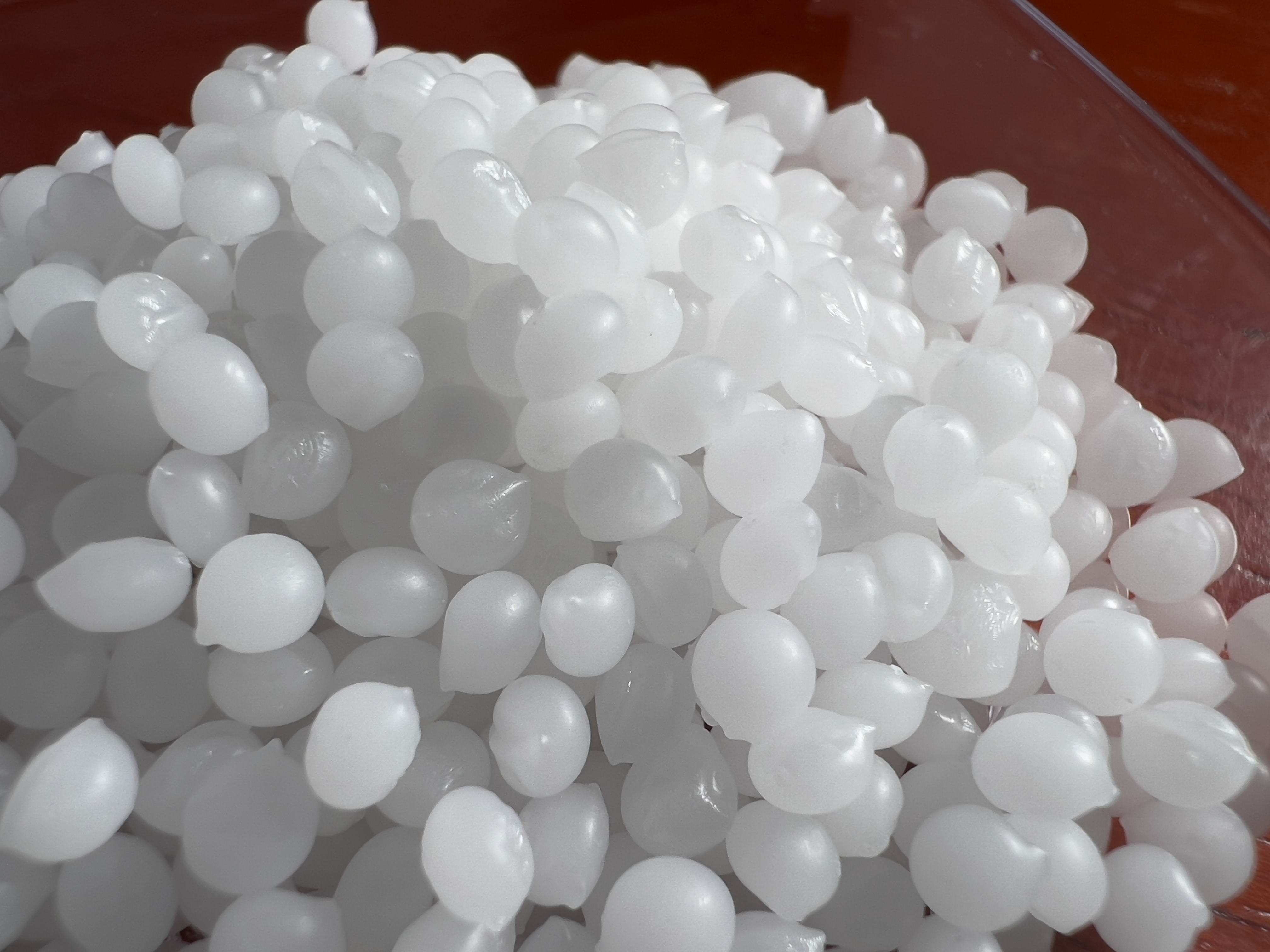A pile of white, waxy Montanov™ 202 pellets. This is an emulsifier.