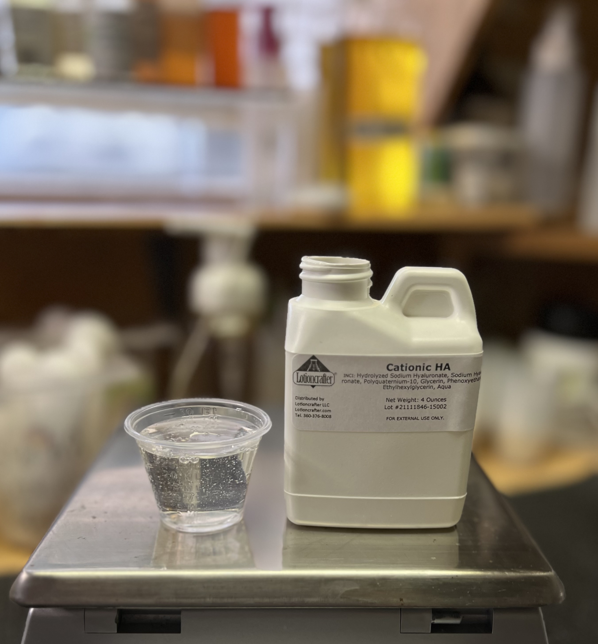 Cationic HA cup with clear liquid and bottle in scale portrait mode