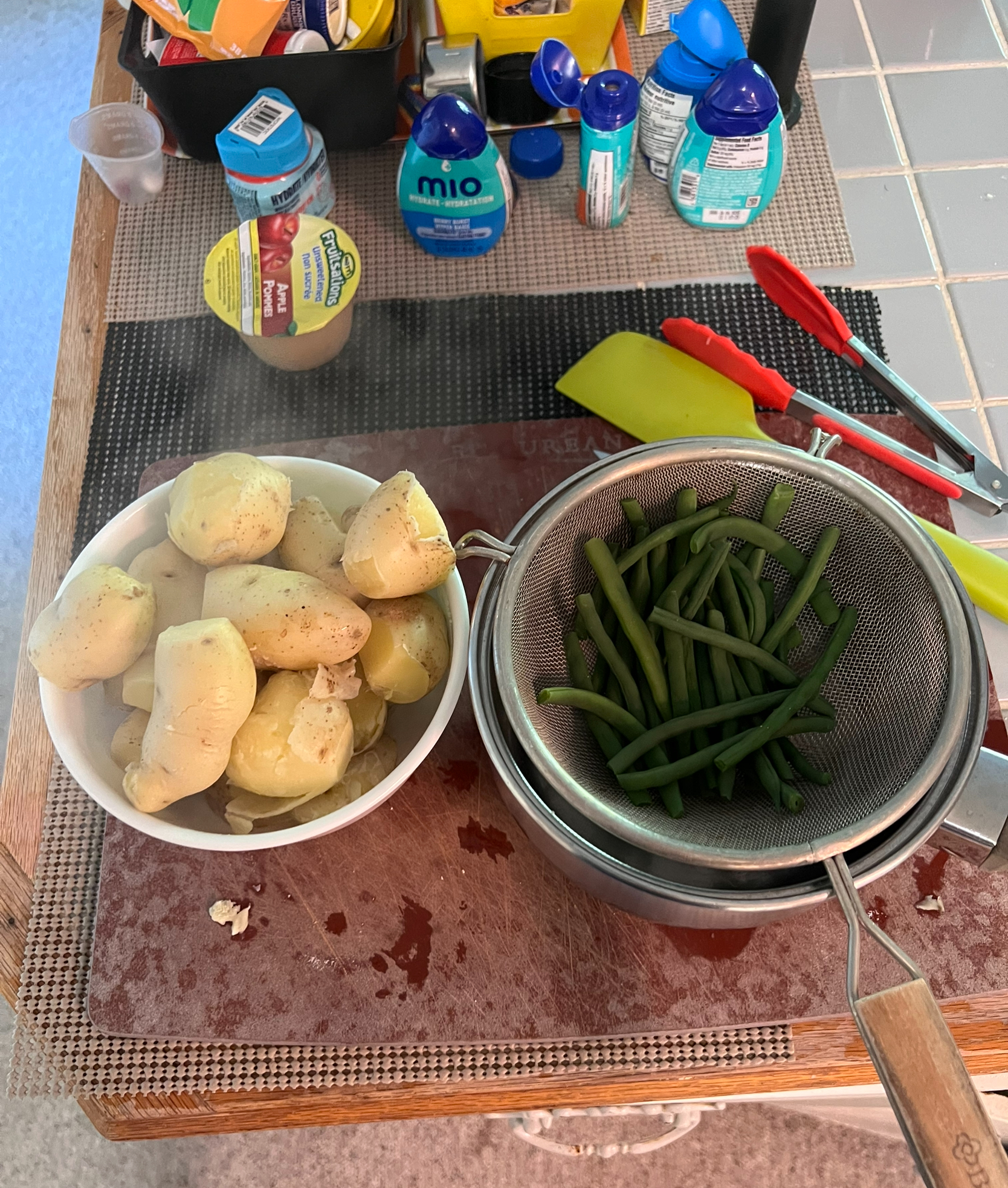 Making dinner with one bowl of potatoes; one bowl of green beans. Both are grown in our garden!