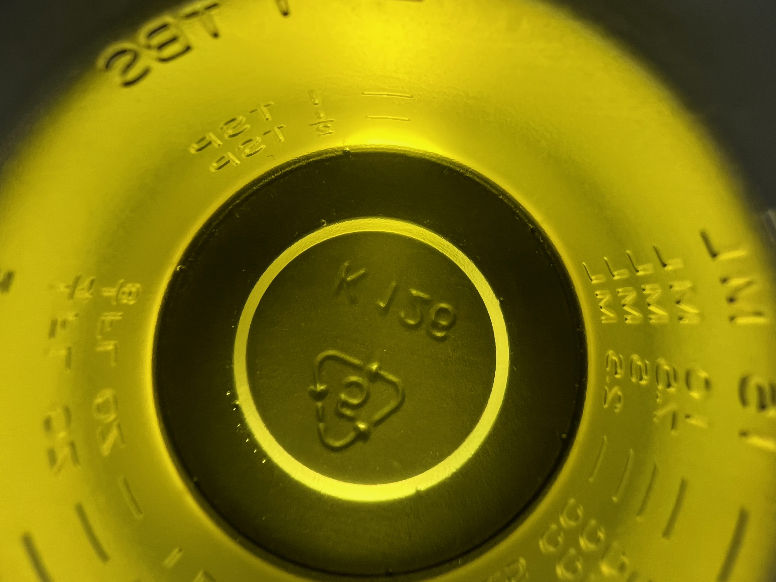 A yellow, thick liquid in a plastic shot glass, looking down at the bottom of the cup. It's avocado oil.